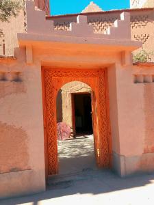 an entrance to a building with an orange door at Kasbah Les Nomades in Skoura