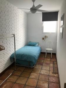 - une chambre avec un lit et un mur en briques blanches dans l'établissement 1 de 17 CASA CON JARDÍN PRIVADO A 200m DE LA PLAYA., à Vera