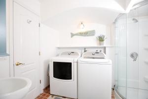 a white kitchen with a microwave and a sink at The Montauk Soundview in Montauk +154 photos