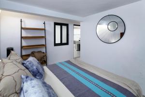 een slaapkamer met een bed en een spiegel aan de muur bij Villa Robalo A in Sayulita