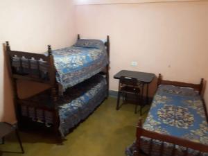 a bedroom with two bunk beds and a table at Hospedaje TUUKAY in Tilcara