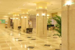 a lobby with columns and chairs in a building at Miyako Hotel Amagasaki in Amagasaki