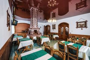 restauracja ze stołami i krzesłami w pokoju w obiekcie Villa Ignatyeva w mieście Schodnica