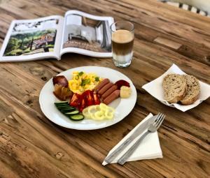 a plate of food on a wooden table with a drink at The Houses of History - anno 1830 in Tihany