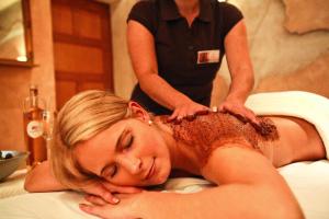 a woman is getting a massage from a spa practition at 4-Sterne Superior Erlebnishotel Colosseo, Europa-Park Freizeitpark & Erlebnis-Resort in Rust