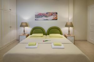 1 dormitorio con 1 cama con cabecero verde y 2 lámparas en Villa Rebecca, en Kalamata 32 fotos más