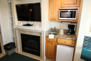 a small kitchen with a fireplace and a microwave at Ocean Club on Smuggler's Beach in South Yarmouth