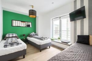 ワルシャワにあるLabo Apartment Dzialdowskaの緑の壁のベッドルーム1室(ベッド2台付)