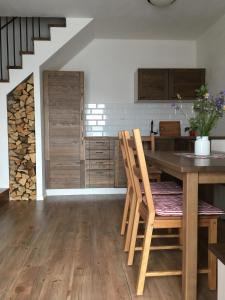 a kitchen with a table and chairs and a staircase at Chaty Pohoda na Soláni in Velké Karlovice