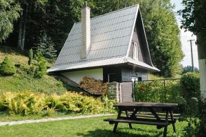 una mesa de picnic frente a una pequeña iglesia en Chaty Pohoda na Soláni, en Velké Karlovice