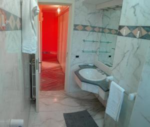 baño con lavabo y puerta roja en Appartamento Corrado en Avola