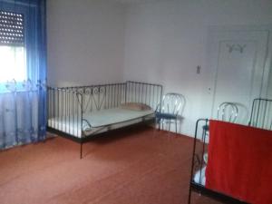 łóżko w pokoju z 2 krzesłami i oknem w obiekcie Pension Ehringshausen w mieście Ehringshausen