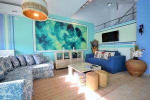 ルートラキにあるLoutraki Diamond beach houseの青いリビングルーム(ソファ、テーブル付)