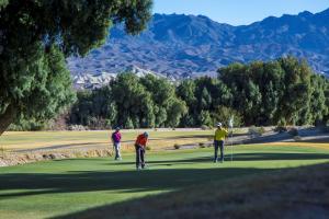 3 Männer spielen Golf auf einem Golfplatz in der Unterkunft The Inn at Death Valley in Indian Village
