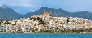 a group of white buildings on a hill next to the water at Ashanti Bay Luxury Golf Apartment in Altea