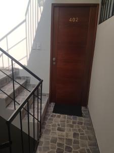 una puerta de madera con el número al lado de las escaleras en Lima Flats, en Lima