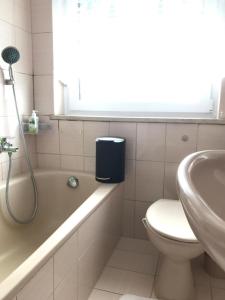 Un baño con bañera, inodoro y lavabo. en Isas Apartment, en Füssen