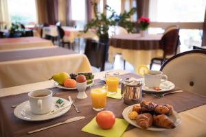 a table with plates of food and cups of orange juice at Kyriad Toulouse Blagnac Aéroport in Blagnac