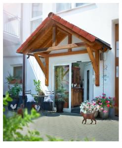 awning on the front of a house with flowers at Landhaus-Apartments in Wattenheim