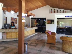 グアラジュバにあるFlat Guarajuba Summer House - Bahiaのレストランのバーに座る女