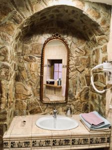 uma casa de banho em pedra com um lavatório e um espelho em Pension & Restaurant Atmosféra em Loket