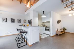 an open kitchen with white cabinets and a ladder at SOBRI Cork House - Sustainable Loft in Porto