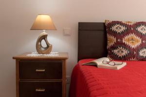 a bedroom with a bed with a lamp and a book at Vivenda Golfinho Barra in Praia da Barra