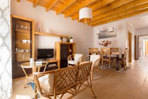 a dining room and living room with a table and chairs at Vivenda Golfinho Barra in Praia da Barra