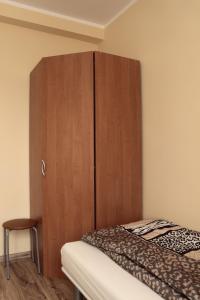 a bedroom with a wooden cabinet next to a bed at Apartamenty Przy Trakcie Cesarskim in Węgierska Górka