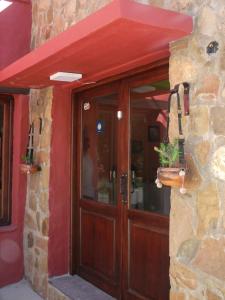 une porte en bois d'un bâtiment avec un toit rouge dans l'établissement Munay Humahuaca, à Humahuaca