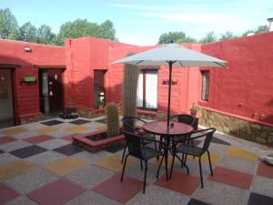 a table and chairs with an umbrella on a patio at Hosteria Felipa Pastor - Ex Munay Humahuaca in Humahuaca