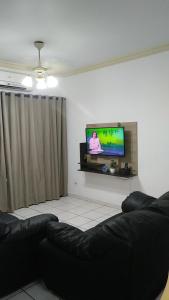 a living room with a flat screen tv on a wall at Apartamento Guarujá in Guarujá