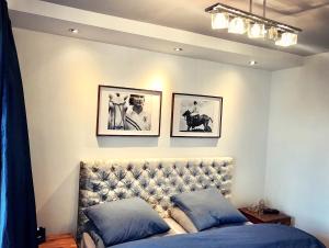 グディニャにある"Cambiani Royal" luksusowy apartament blisko morzaのベッドルーム1室(壁に2枚の写真が飾られたベッド1台付)