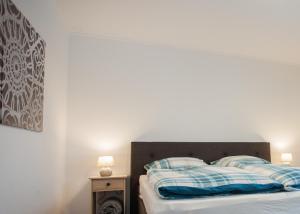 Una cama con almohadas azules y blancas. en Ferienwohnungen Citylight Winterberg, en Winterberg