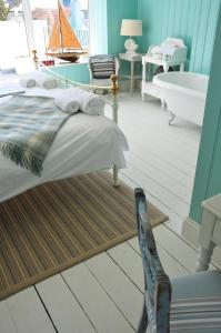 a bedroom with a bed and a bath tub in it at Lulworth Cove Inn in Lulworth Cove