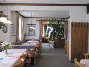 uma sala de jantar com mesas e cadeiras e uma porta em Bei Weirich em Schwangau
