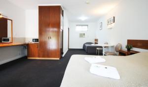 a hotel room with two beds and a living room at Melaleuca Lodge Beaconsfield in Beaconsfield