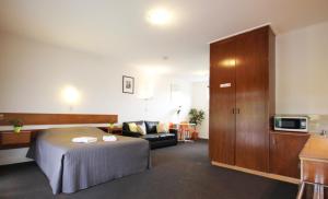 a hotel room with a bed and a couch at Melaleuca Lodge Beaconsfield in Beaconsfield
