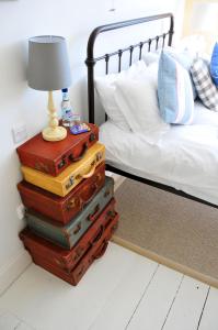 a stack of suitcases sitting next to a bed at Lulworth Cove Inn in Lulworth Cove