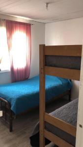 a bedroom with two bunk beds and a window at Casa El Quisco in El Quisco