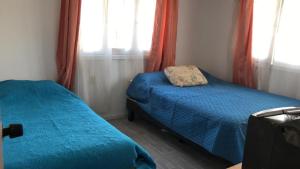 una camera da letto con due letti e due finestre di Casa El Quisco a El Quisco