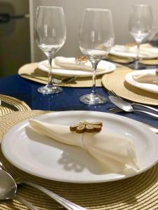 un plato blanco con una servilleta en una mesa con copas de vino en Apto. Novo Landscape Beira Mar, en Fortaleza