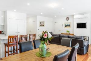 a dining room with a table with a vase of flowers at Olinda Deluxe Apartment B1 in Olinda