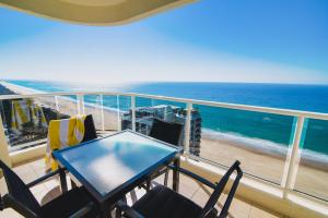 a balcony with a table and chairs and the ocean at Xanadu Resort in Gold Coast