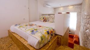 a bedroom with a bed with a floral comforter at Bemyguest - Loft Guest House Jardim das Mães Charming in Viseu