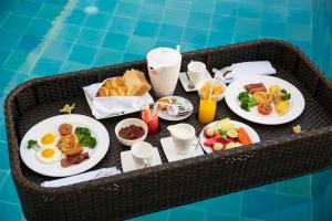uma bandeja de comida de pequeno-almoço numa mesa ao lado de uma piscina em C151 Smart Villas at Seminyak em Seminyak