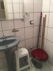 W łazience znajduje się czerwona toaleta i umywalka. w obiekcie Apts no Condominio Quisisana w mieście Poços de Caldas