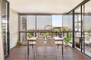 a dining room with a table and chairs and large windows at Stylish 1 bdrm Camperdown - Car park, Gym & Pool in Sydney
