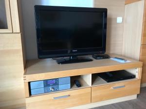 シュタインにあるSteiner Strandappartements Studio-Appartement 104 Seeseiteの木製エンターテイメントセンターの上に座って薄型テレビを設置