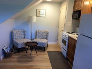 a small kitchen with two chairs and a table at D'Angelo Winery Farm House in Penticton